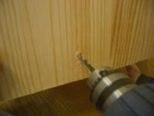 電気ドリルで木材に穴を開ける