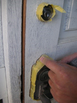 玄関ドアの塗装前にドアノブなどをマスカーテープで保護する
